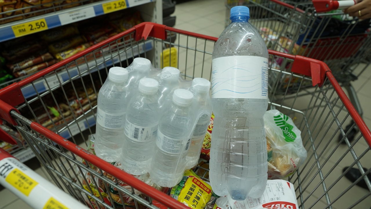 Six-pack of small water bottles beside a large 1.5 litre bottle