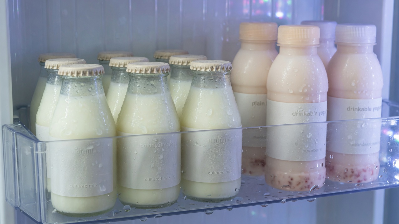 Cultured milk bottles next to yogurt drinks in a fridge door